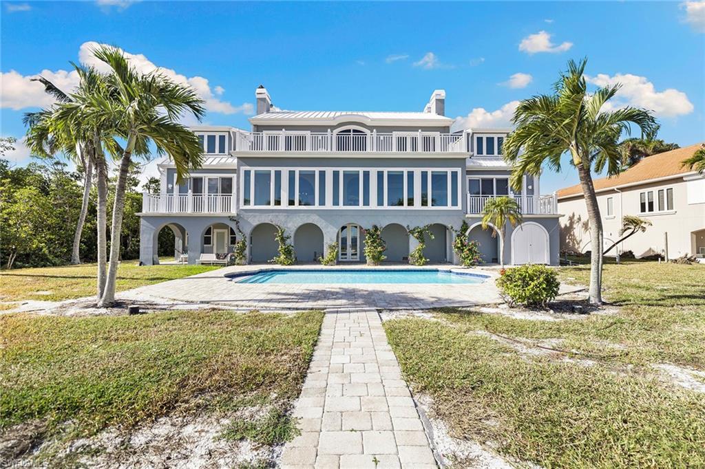 1069 Bird Lane Sanibel, FL 33957 - Photo 6 of 46 a view of a house with swimming pool and a yard