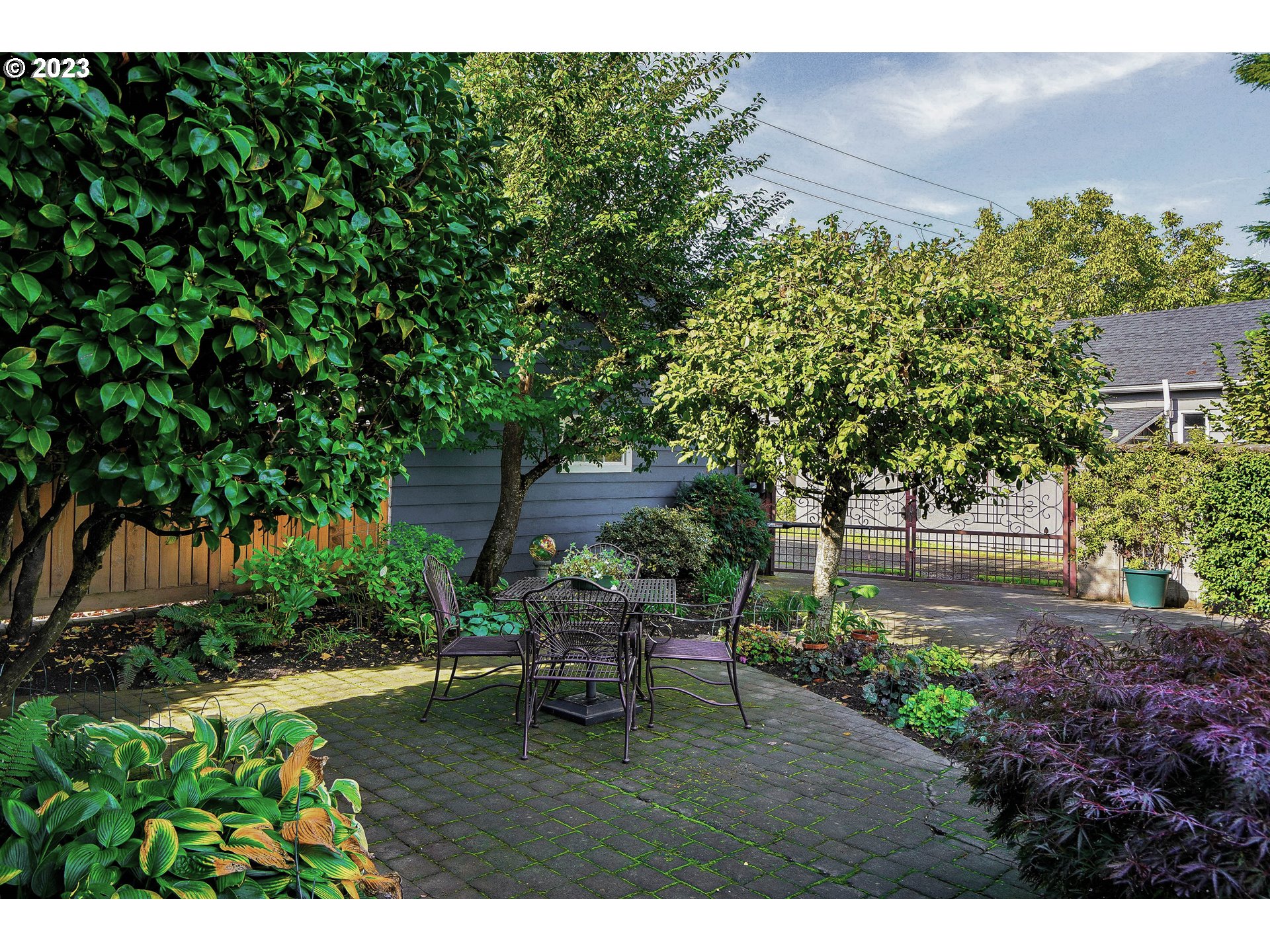810 North Water Street Silverton, OR 97381 - Photo 39 of 48 a backyard of a house with table and chairs plants and large tree