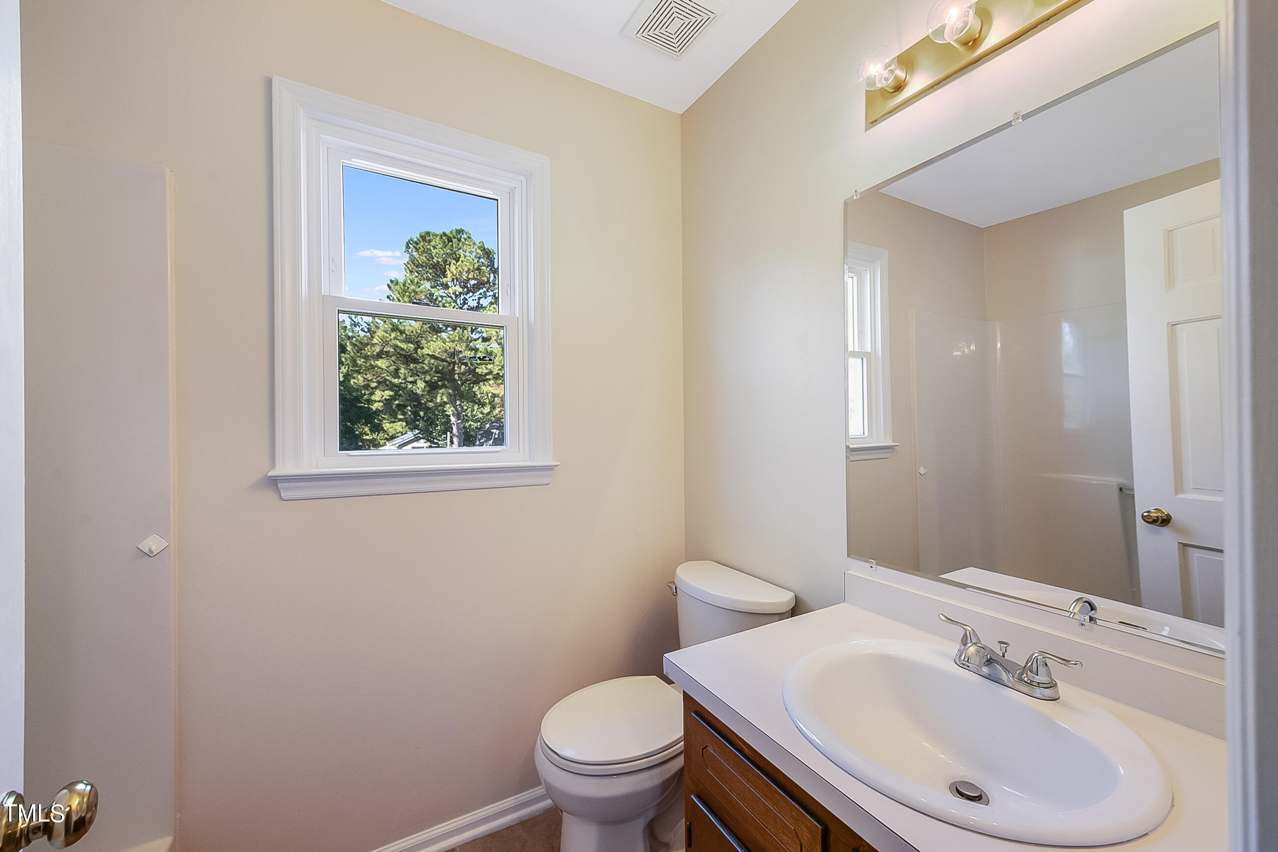 10024 Joe Leach Road Raleigh, NC 27603 - Photo 15 of 26 a bathroom with a sink a toilet and mirror
