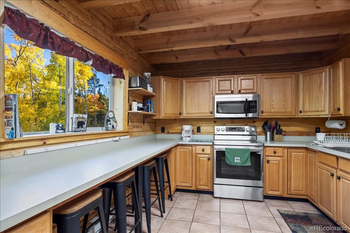1119 Venture Road Fairplay, CO 80440 - Photo 17 of 49 a kitchen with stainless steel appliances granite countertop a table chairs sink and cabinets