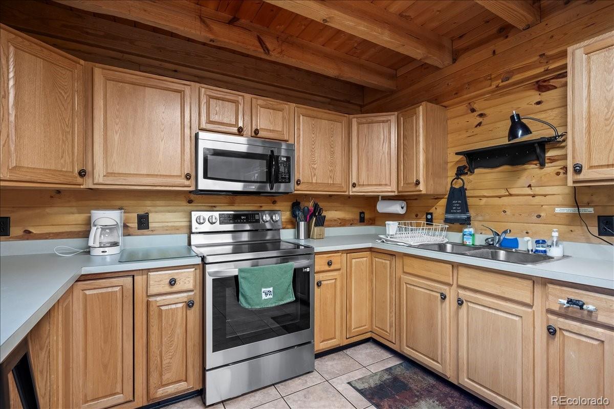 1119 Venture Road Fairplay, CO 80440 - Photo 18 of 49 a kitchen with stainless steel appliances granite countertop a sink a stove a microwave and cabinets