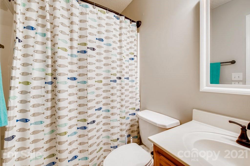 8210 Rudolph Road Charlotte, NC 28216 - Photo 10 of 11 a white toilet sitting next to a shower curtain