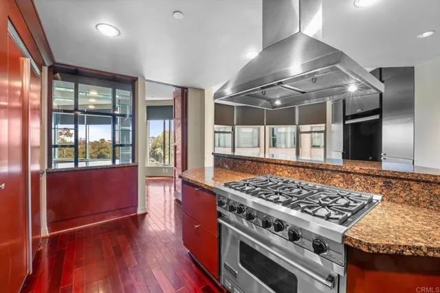 a kitchen with stainless steel appliances granite countertop a stove and a wooden floors