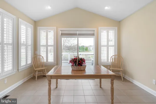 a dining room with furniture and large windows