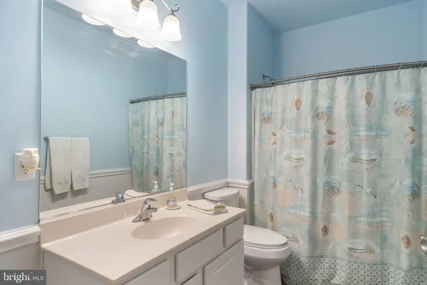 a bathroom with a sink a toilet and a large mirror