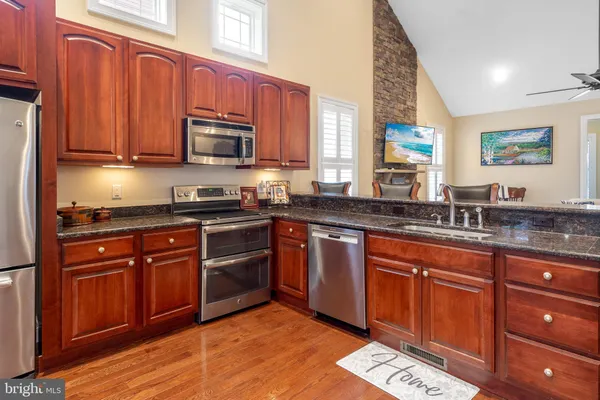 a kitchen with stainless steel appliances granite countertop a sink stove and microwave