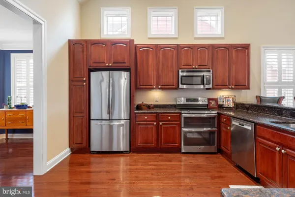 a kitchen with stainless steel appliances granite countertop a refrigerator stove and sink