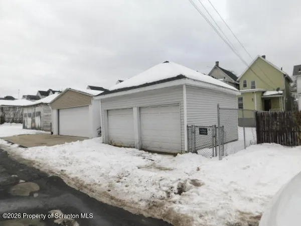 a view of a house with a yard covered in snow
