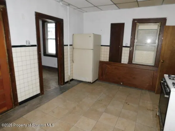 a view of kitchen with refrigerator and cabinet
