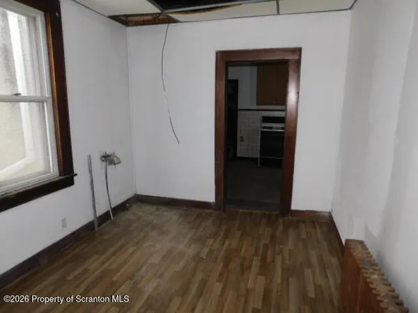 a view of a small space with wooden floor and a window