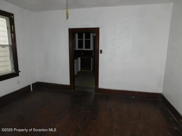 an empty room with wooden floor and cabinet