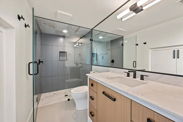 a bathroom with a sink a toilet and shower