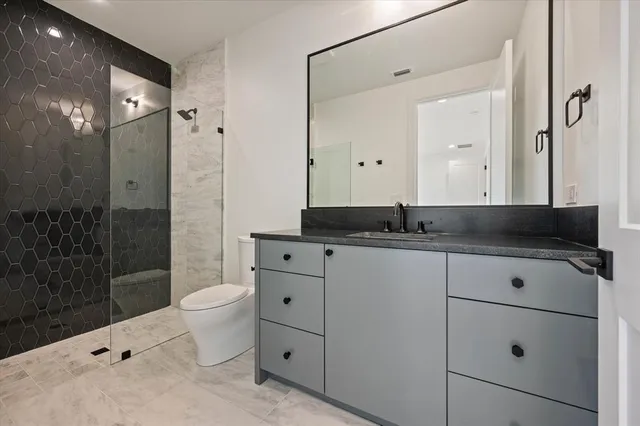 a bathroom with a shower toilet sink and mirror