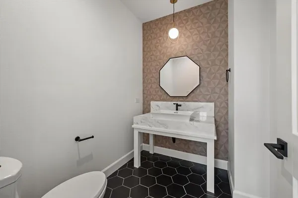 a bathroom with a sink toilet and a mirror