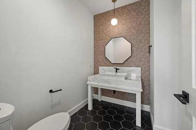 a bathroom with a sink toilet and a mirror