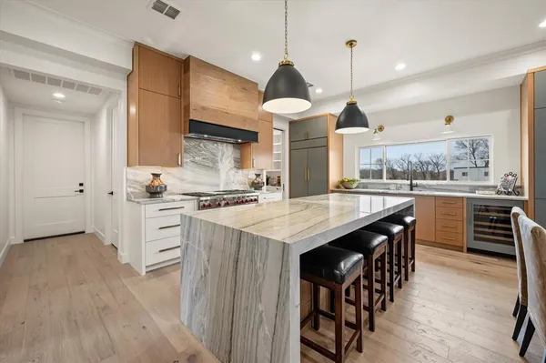 a kitchen with stainless steel appliances kitchen island granite countertop a stove a sink a refrigerator and a cabinets