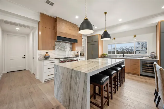 a kitchen with stainless steel appliances kitchen island granite countertop a stove a sink a refrigerator and a cabinets