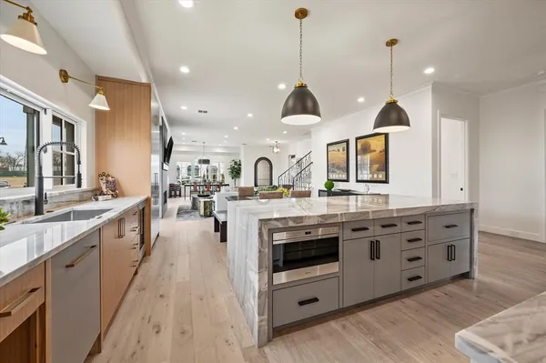 a large kitchen with stainless steel appliances and a wooden floor
