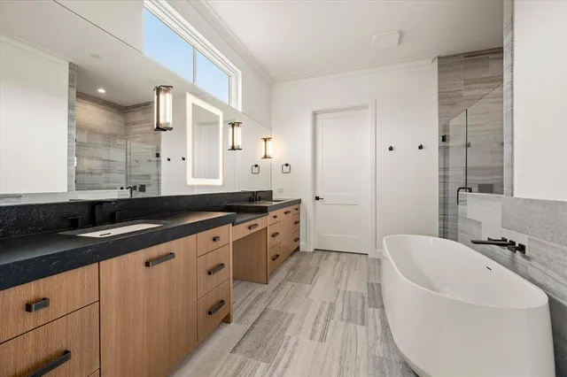 a spacious bathroom with a granite countertop sink a mirror and a bathtub