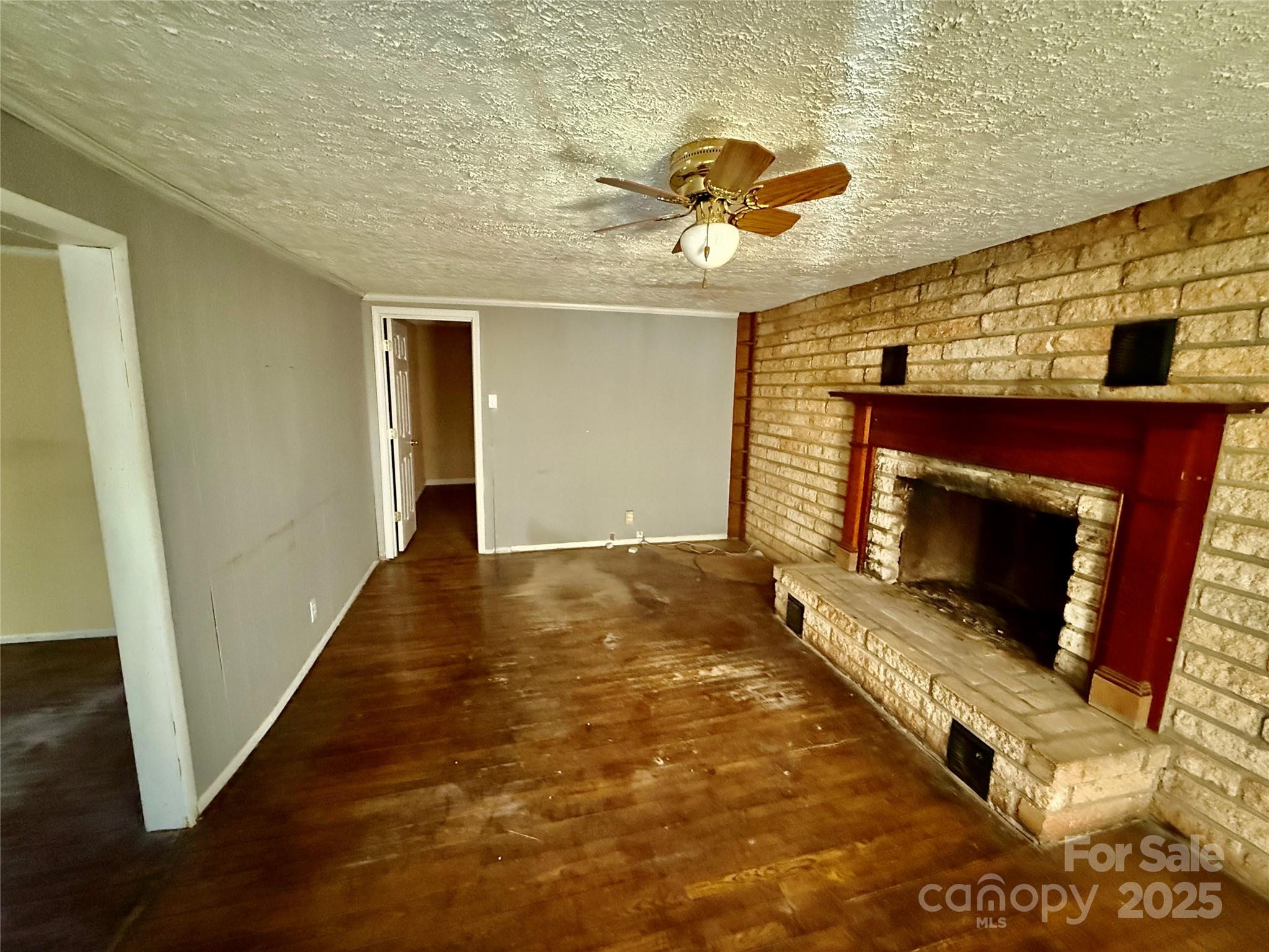 602 Green Chapman Road Gastonia, NC 28056 - Photo 2 of 10 a view of an empty room with wooden floor and a fireplace