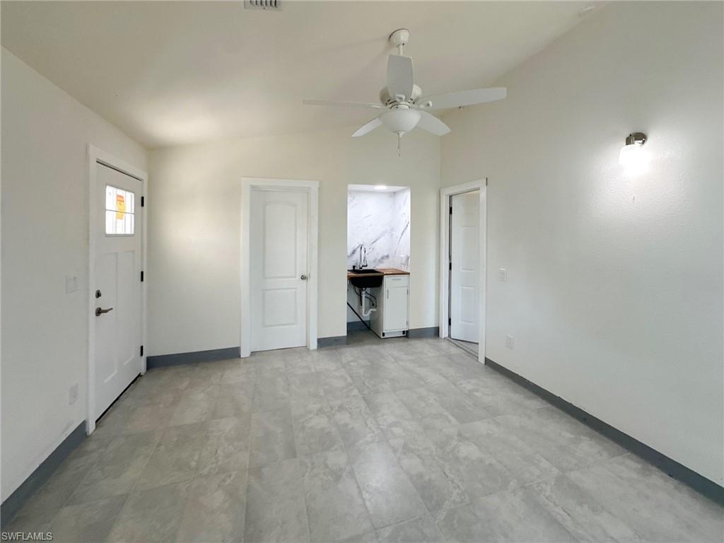 137 Meta Street Fort Myers, FL 33905 - Photo 19 of 50 Unfurnished living room featuring lofted ceiling and ceiling fan