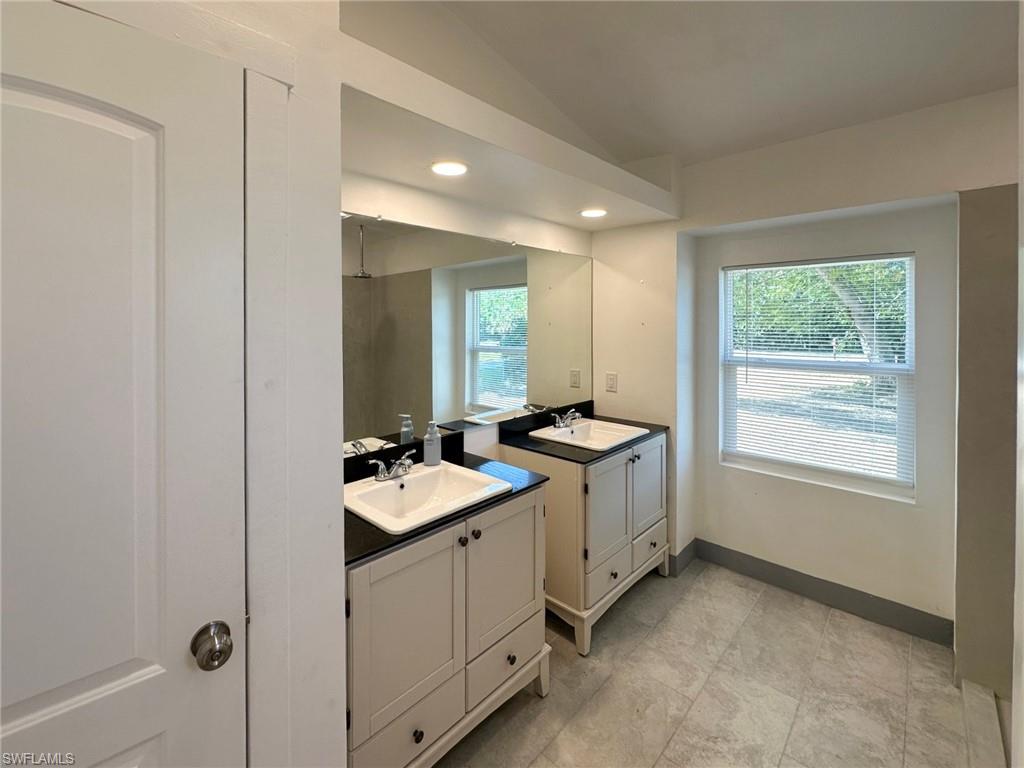 137 Meta Street Fort Myers, FL 33905 - Photo 22 of 50 Bathroom featuring vaulted ceiling, two vanities, healthy amount of natural light, and recessed lighting