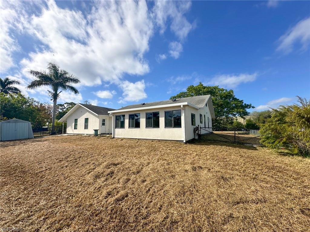 137 Meta Street Fort Myers, FL 33905 - Photo 4 of 50 Rear view of house featuring stucco siding and a storage unit