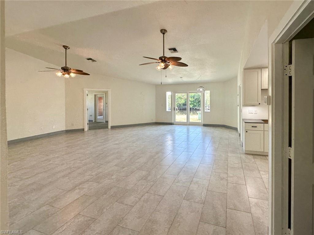 137 Meta Street Fort Myers, FL 33905 - Photo 7 of 50 Unfurnished living room featuring ceiling fan and lofted ceiling