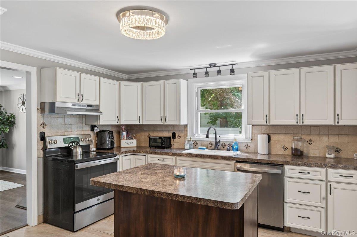 4 Myrtle Lane Coram, NY 11727 - Photo 8 of 20 a kitchen with stainless steel appliances granite countertop a sink a stove a refrigerator cabinets and a window