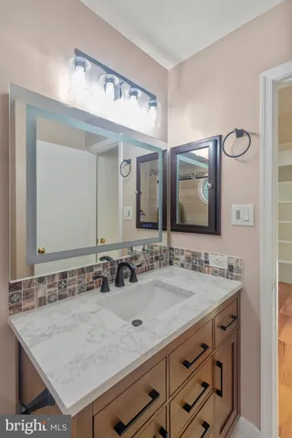 a bathroom with a sink vanity and a mirror