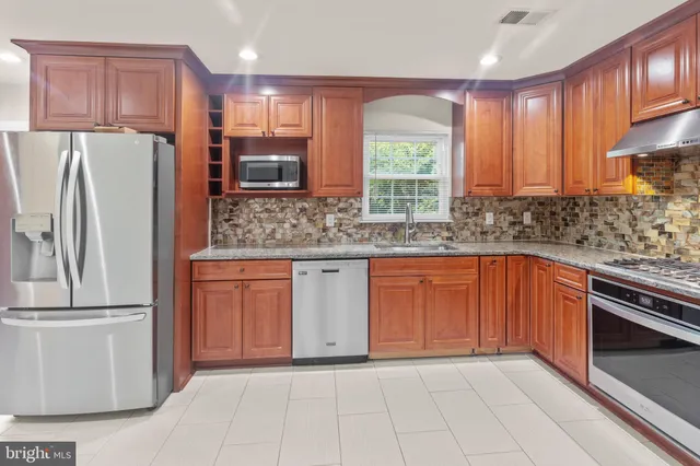 a kitchen with stainless steel appliances granite countertop a refrigerator sink and cabinets