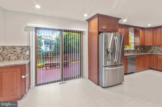 a kitchen with stainless steel appliances granite countertop a refrigerator and a sink