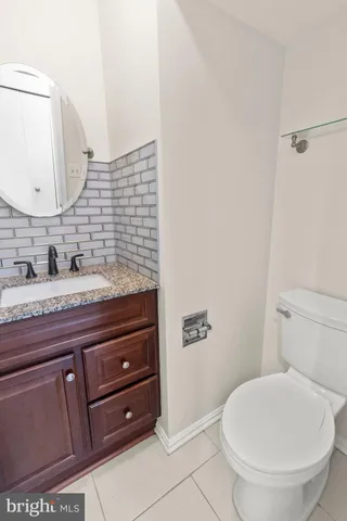 a bathroom with a granite countertop toilet sink and mirror