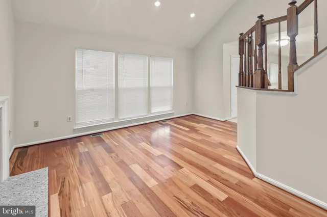 a view of an empty room with wooden floor