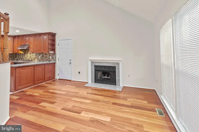 a view of an empty room with a fireplace and a window