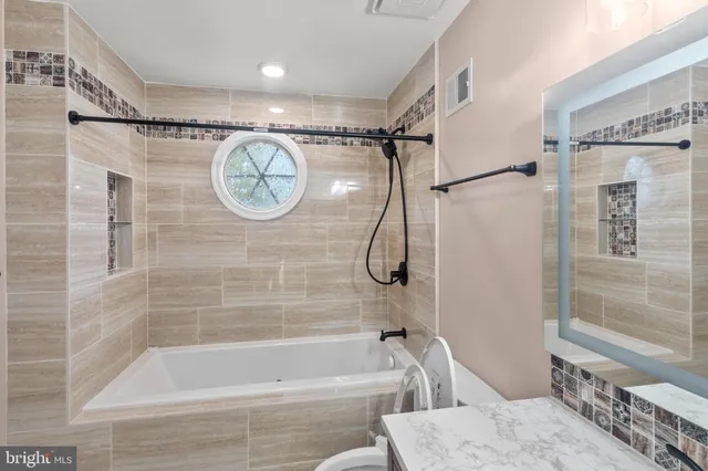 a bathroom with a bath tub a toilet and a shower