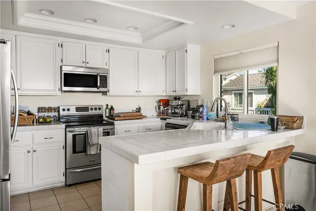 a kitchen with stainless steel appliances a stove a sink a microwave a refrigerator and cabinets