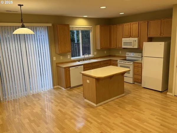 a kitchen with stainless steel appliances granite countertop a stove a sink dishwasher and a refrigerator with wooden floor