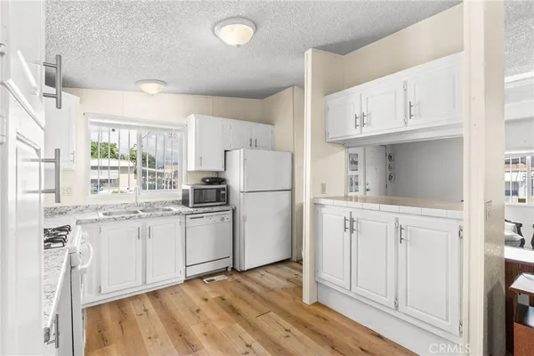a kitchen with white cabinets and white appliances