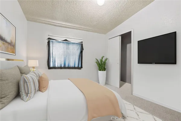 a bedroom with a bed and a flat screen tv