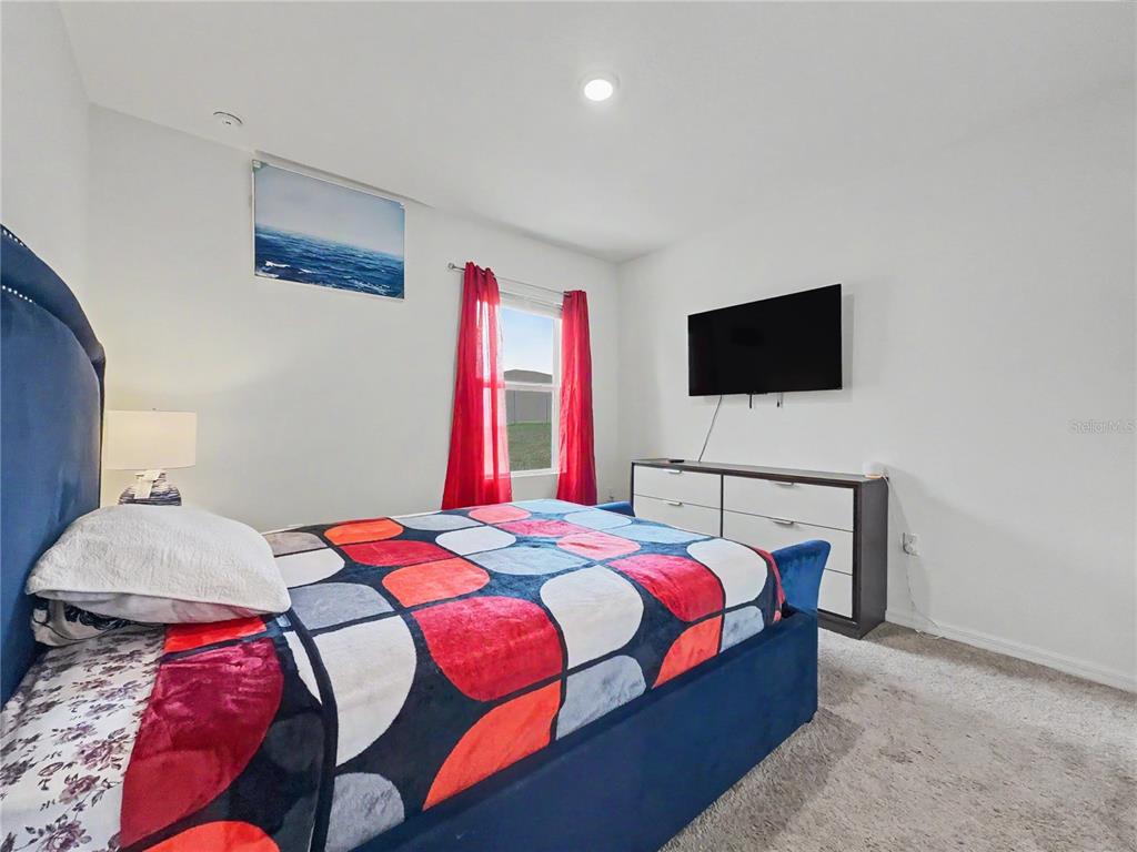 2085 Doe Run Drive Davenport, FL 33837 - Photo 22 of 44 a bedroom with a bed and a flat screen tv