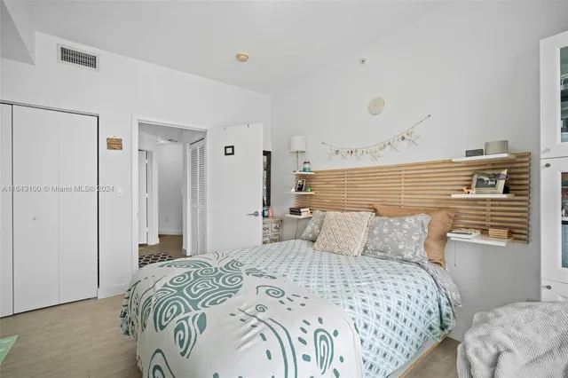 a bedroom with a bed a table and a large mirror