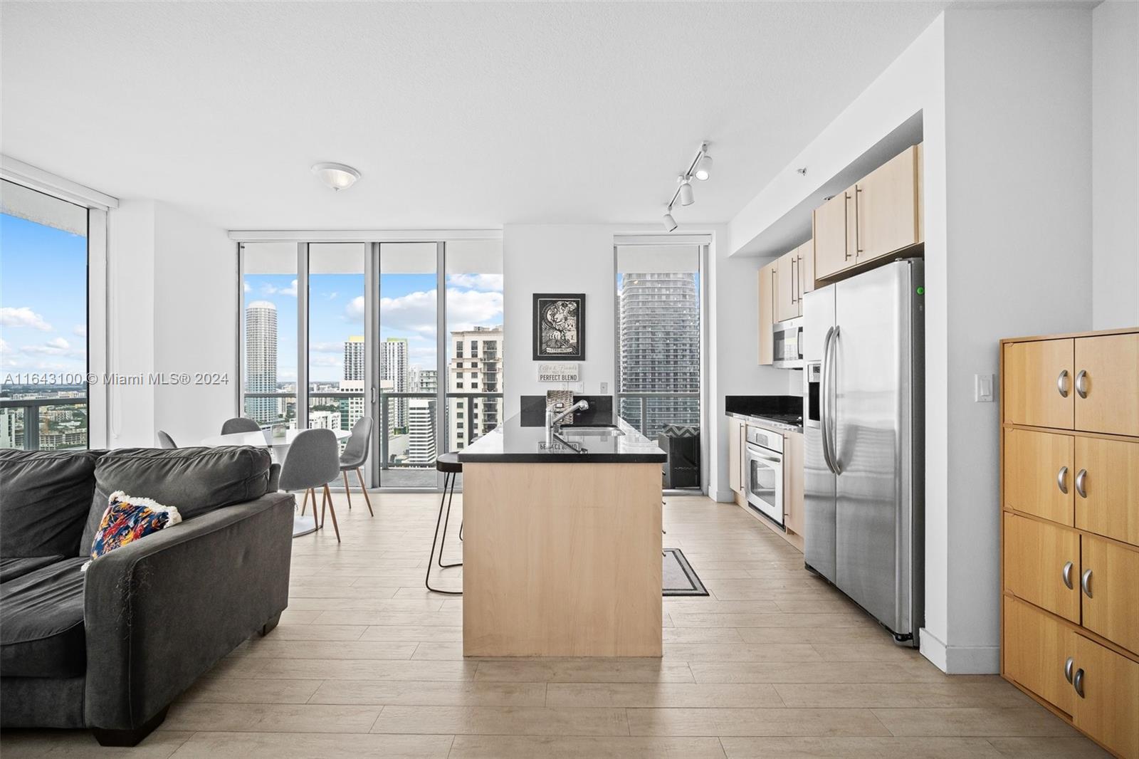 1111 Southwest 1st Avenue, Unit 3425N Miami, FL 33130 - Photo 5 of 35 a large open kitchen with stainless steel appliances kitchen island a large window and a refrigerator