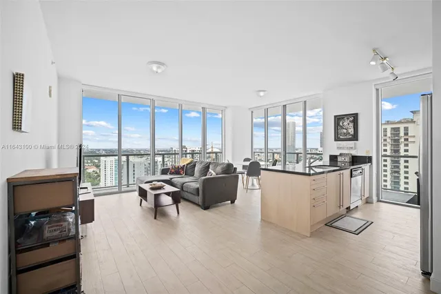 a kitchen with stainless steel appliances a refrigerator a sink and white cabinets