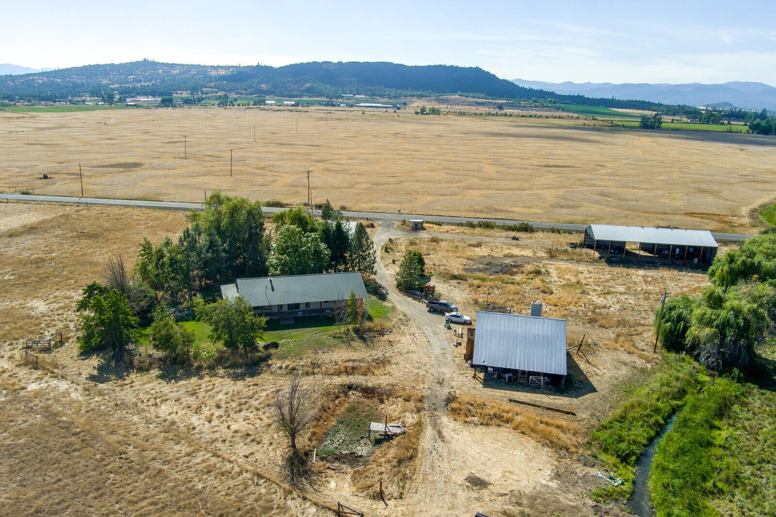 10 acres w/ irrigation, fenced, 2 barns, pond