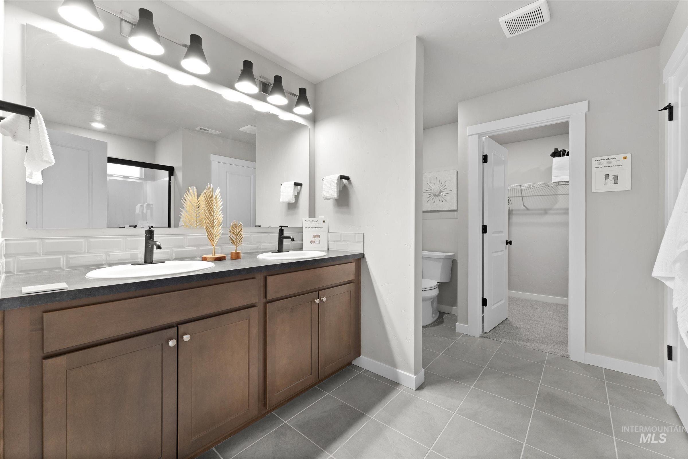 4141 South Colditz Way Meridian, ID 83642 - Photo 17 of 40 Full bathroom featuring a shower stall, double vanity, light tile patterned floors, a walk in closet, and decorative backsplash