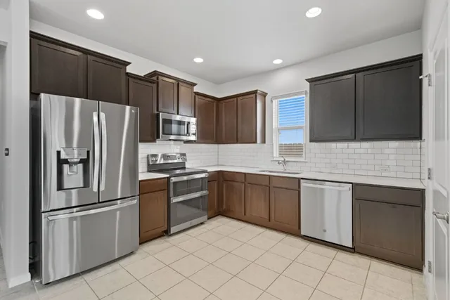a kitchen with granite countertop stainless steel appliances and white cabinets