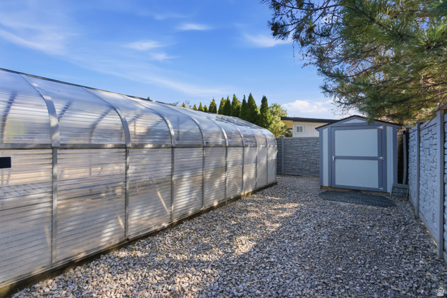145 Carnesecca Court Mapleton, UT 84664 - Photo 87 of 109 Fenced backyard featuring a greenhouse and a shed