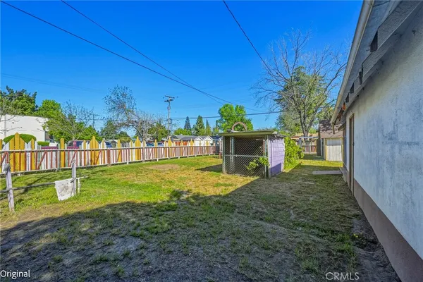 a view of a small house with wooden fence