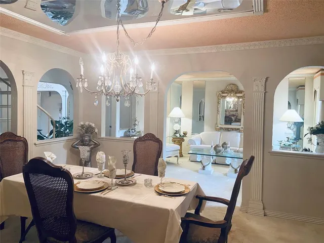 a view of a dining room with furniture and a chandelier